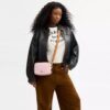 Borsa a tracolla Mini Carey in Signature Canvas con ciondoli