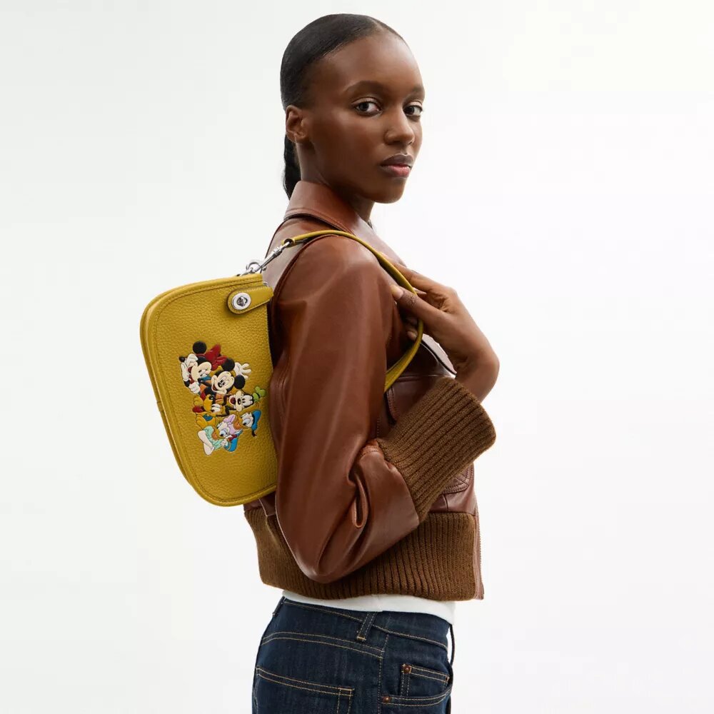 Borsa Swinger Disney X Coach in pelle rigenerativa con Topolino e i suoi amici