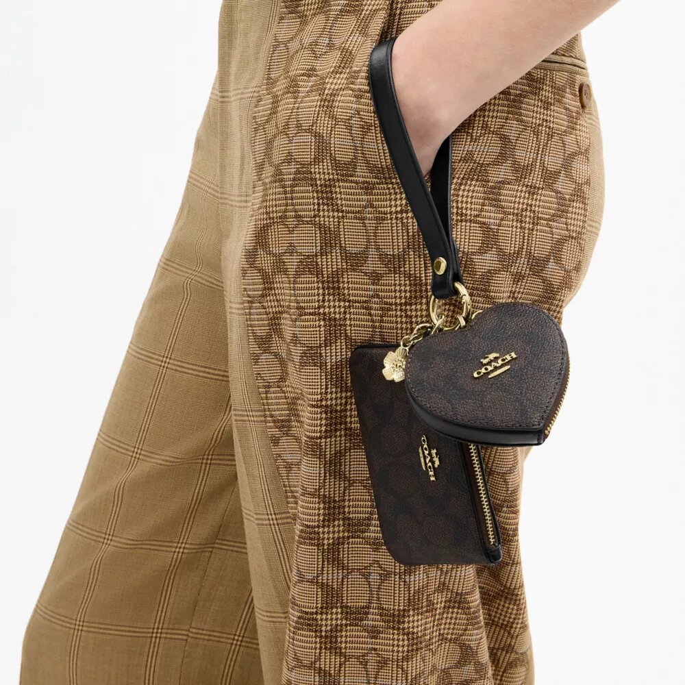Borsello da polso e pochette a forma di cuore in Signature Canvas con ciondolo