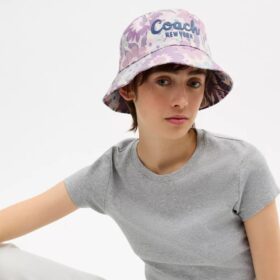 Cappello a secchiello con stampa floreale e scritta Coach in corsivo