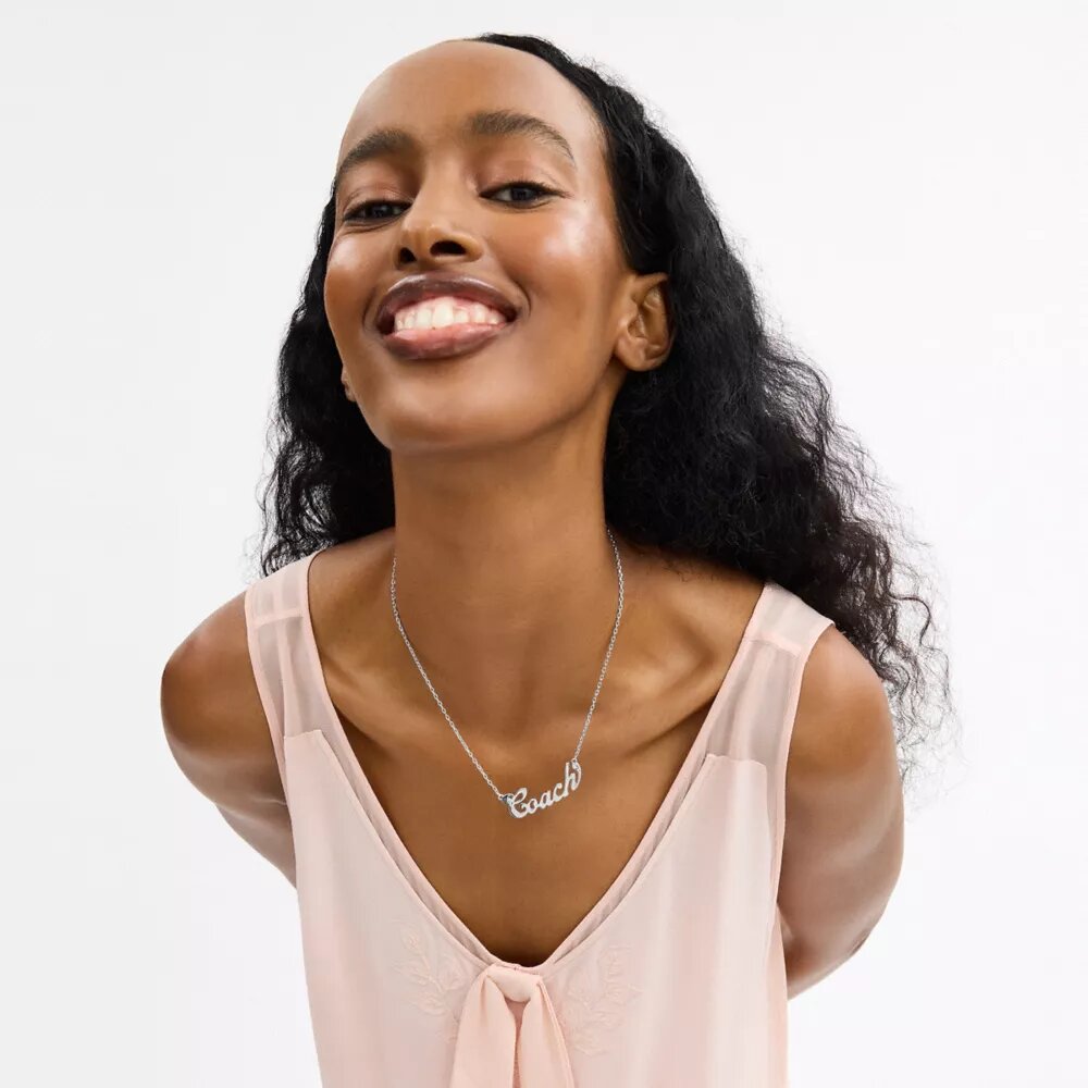 Collana con targhetta in stile Coach Script